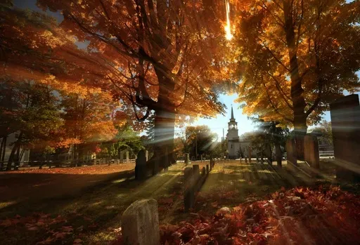 In this photo taken with a slow shutter speed, autumn's colors peak on hardwood trees in a cemetery near the Congregational Church, Monday, Oct. 10, 2016, in Cumberland, Maine. (AP Photo/Robert F. Bukaty, File)