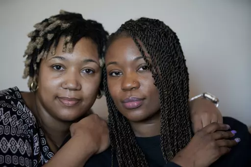 Sisters Angelica Lyons, left, and Ansonia Lyons pose for a portrait at their parents' home in Birmingham, Ala., on Saturday, Feb. 5, 2022. As a public health instructor, Angelica taught college students about racial health disparities, including the fact that Black women in the U.S. are nearly three times more likely to die during pregnancy or delivery than any other race. Then, in 2019, it nearly happened to her. Ansonia also had several difficulties when she became pregnant in 2020. (AP Photo/