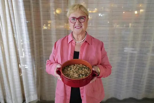 This image released by PBS shows celebrity chef Lidia Bastianich holding her recipe for escarole and white bean soup in Washington, DC on Nov. 7, 2022. The Emmy-award winning TV host, author and restaurateur explores the immigrant experience through food in the PBS special "Lidia Celebrates America: Flavors That Define Us.” (Meredith Nierman/PBS via AP)
