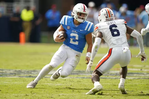 Mississippi quarterback Jaxson Dart (2) tries to evade a tackle attempt by Auburn cornerback Keionte Scott (6) during the second half of an NCAA college football game in Oxford, Miss., Saturday, Oct. 15, 2022. Mississippi won 48-34. (AP Photo/Rogelio V. Solis)