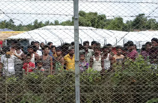 Rohingya refugees gather near a fence during a government organized media tour, to a no-man's land between Myanmar and Bangladesh, near Taungpyolatyar village, Maung Daw, northern Rakhine State, Myanmar, June 29, 2018. An international case accusing Myanmar of genocide against the Rohingya ethnic minority returns to the United Nations' highest court Monday, Feb. 21, 2022, amid questions over whether the country's military rulers should even be allowed to represent the Southeast Asian nation. (AP