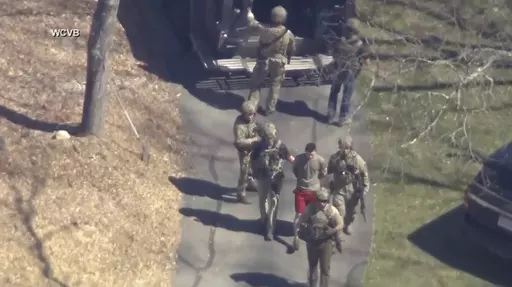 This image made from video provided by WCVB-TV, shows Jack Teixeira, in T-shirt and shorts, being taken into custody by armed tactical agents on Thursday, April 13, 2023, in Dighton, Mass. Teixeira, who is accused in the leak of highly classified military documents, appeared in court Friday as prosecutors unsealed charges and revealed how billing records and interviews with social media comrades helped pinpoint the suspect. (WCVB-TV via AP, File)