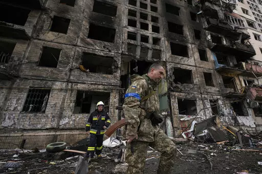Ukrainian soldiers and firefighters search in a destroyed building after a bombing attack in Kyiv, Ukraine, Monday, March 14, 2022. (AP Photo/Vadim Ghirda, File)