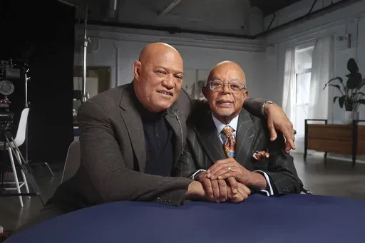 This image released by PBS shows actor Laurence Fishburne, left, with Dr. Henry Louis Gates Jr., host of the series “Finding Your Roots." (PBS via AP)