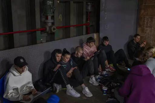 People sit in the Kyiv subway, using it as a bomb shelter, in Kyiv, Ukraine, on Wednesday, Oct. 19, 2022. (AP Photo/Emilio Morenatti)