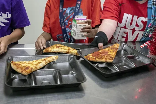 Second-grade students select their meals during lunch break in the cafeteria at an elementary school in Scottsdale, Ariz., Dec. 12, 2022. (AP Photo/Alberto Mariani, File)