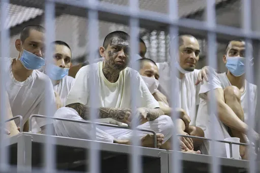 Prisoners look out from their cell as the Costa Rica Justice and Peace minister tours the Terrorist Confinement Center in Tecoluca, El Salvador, Friday, April 4, 2025. (AP Photo/Salvador Melendez)