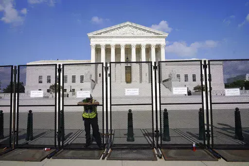 An officer rests on a fence outside the Supreme Court in Washington, Friday, June 24, 2022. The Supreme Court has ended constitutional protections for abortion that had been in place nearly 50 years, a decision by its conservative majority to overturn the court's landmark abortion cases. (AP Photo/Jacquelyn Martin)