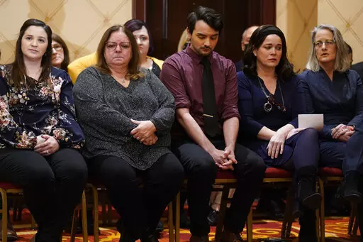 Families of the victims of the Newtown shooting and attorneys listen during a news conference in Trumbull, Conn., Tuesday, Feb. 15, 2022. The families of nine victims of the Sandy Hook Elementary School shooting have agreed to a $73 million settlement of a lawsuit against the maker of the rifle used to kill 20 first graders and six educators in 2012, their attorney said Tuesday. (AP Photo/Seth Wenig)