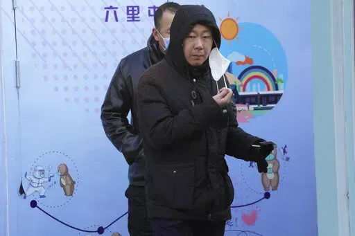 A resident pulls away a mask during COVID test in Beijing, Wednesday, Dec. 7, 2022. In a sharp reversal, China has announced a series of measures rolling back some of the most draconian anti-COVID-19 restrictions. (AP Photo/Ng Han Guan)