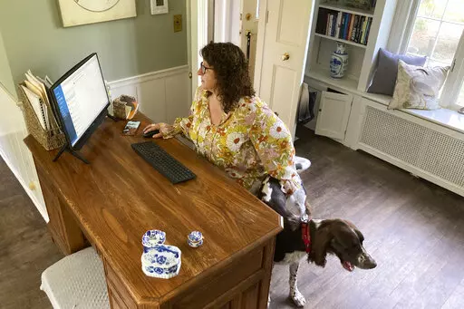 Sarah Motiff, from politically competitive Columbia, County, Wisconsin, works from home in Columbus, Wis., on Sept. 13, 2022. The 52-year-old city council woman and political independent says testimony that Republican Wisconsin Sen. Ron Johnson's office offered a fake slate of Wisconsin electors for the 2020 election "put a bad taste in my mouth." She is among independent voters nationally who have drifted toward supporting Democrats this fall. (AP Photo/Thomas Beaumont)