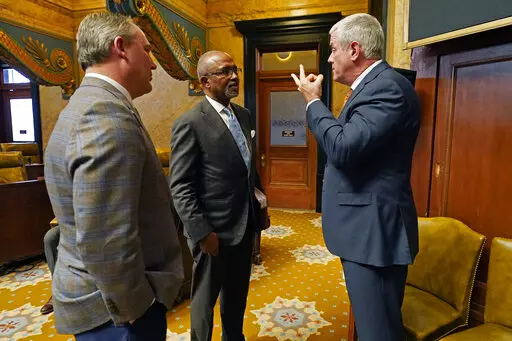 Rep. Robert Johnson, D-Natchez, center, confers with House Speaker Philip Gunn, R-Clinton, right, and House Speaker Pro Tempore Jason White, R-West, during a break, in chamber, Monday, March 28, 2022, at the Mississippi Capitol in Jackson. (AP Photo/Rogelio V. Solis)