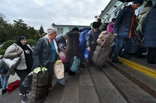 Evacuees from Kherson gather upon their arrival at the railway station in Dzhankoi, Crimea, Friday, Oct. 21, 2022. Russian authorities have encouraged residents of Kherson to evacuate, warning that the city may come under massive Ukrainian shelling. (AP Photo)