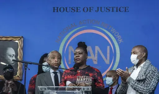Rev. Al Sharpton, third from left, president of the National Action Network (NAN), and Mayor Eric Adams, far right, stand next to Sybrina Fulton, center, the mother of Trayvon Martin, as she address a rally commemorating the 10th anniversary of her son's killing, Saturday Feb. 26, 2022, at NAN's Harlem headquarters in New York. "Today is a bittersweet day," said Fulton, who with her family created the Trayvon Martin Foundation to raise awareness of gun violence. (AP Photo/Bebeto Matthews)