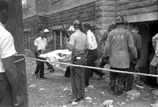 Firefighters and ambulance attendants remove a covered body from the 16th Street Baptist Church in Birmingham, Ala., after a deadly explosion detonated by members of the Ku Klux Klan during services on Sept. 15, 1963. Threats against Black institutions are deeply rooted in U.S. history and leaders say the history of violence against people of color should be passed on to new generations so the lessons of the past can be applied to the present. (AP Photo, File)