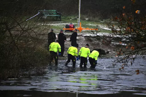 Police search teams at the scene after children fell through ice,in Babbs Mill Park in Kingshurst, Solihull, England, Monday, Dec. 12, 2022. Three young boys who fell through ice covering a lake in central England have died and a fourth remains hospitalized as weather forecasters issued severe weather warnings for large parts of the United Kingdom. Rescuers pulled the boys, aged 8, 10 and 11, from the icy waters Sunday afternoon and rushed them to the hospital in the West Midlands, about 100 mil