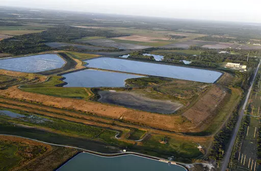 This aerial photo taken from an airplane shows a reservoir near the old Piney Point phosphate mine on April 3, 2021, in Bradenton, Fla. The polluted leftovers of Florida's phosphate fertilizer mining industry, more than 1 billion tons in “stacks” that resemble enormous ponds, are at risk for leaks or other contamination triggered by Hurricane Ian, said environmental groups Tuesday, Sept. 27, 2022. (Tiffany Tompkins/The Bradenton Herald via AP, File)