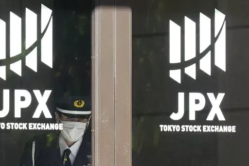 A security guard stands guard at the entrance of the Tokyo Stock Exchange building Wednesday, Nov. 2, 2022, in Tokyo. Asian shares were mostly higher Wednesday ahead of a decision by the U.S. Federal Reserve on an interest rate increase to curb inflation. (AP Photo/Eugene Hoshiko)