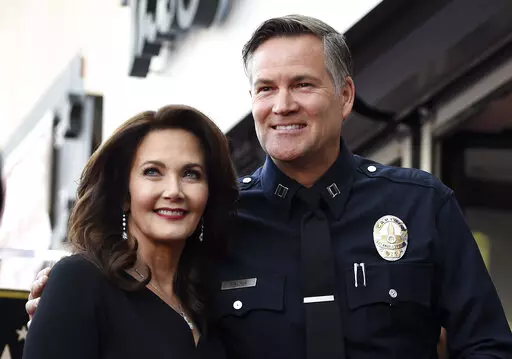 Actor Lynda Carter, left, poses with former Los Angeles Police Department Captain Cory Palka during a ceremony to award her a star on the Hollywood Walk of Fame, Tuesday, April 3, 2018, in Los Angeles. Palka's ties to Hollywood are under scrutiny after prosecutors say he leaked a sexual assault victim's confidential police report to CBS and its former leader Les Moonves. (AP Photo/Chris Pizzello, File)