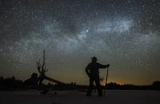 Dave Cooke observes the Milky Way over a frozen fish sanctuary in central Ontario, north of Highway 36 in Kawartha Lakes, Ontario, Canada, early Sunday, March 21, 2021. According to research published in the journal Science on Thursday, Jan. 19, 2023, every year the night sky grows brighter, and the stars look dimmer. Analyzing data from more than 50,000 citizen scientists, or amateur stargazers, reveals that artificial lighting is making the night sky about 10% brighter each year, a faster rate