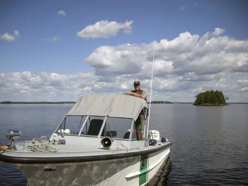 In this undated photo released by the Voyageurs National Park, park ranger Kevin Grossheim, 55, of Kabetogama, Minn., is seen on his boat at Pike Island on Namakan Lake in Voyageurs National Park in northern Minn. (Voyageurs National Park via AP)