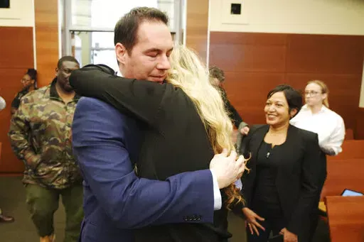 Former Mount Carmel Health doctor William Husel hugs his wife, Mariah Baird, after he was found not guilty on 14 counts of murder in connection with fentanyl overdose deaths of former patients on Wednesday, April 20, 2022 in Columbus, Ohio.  Husel was accused of ordering excessive painkillers for 14 patients in the Mount Carmel Health System. He was indicted in cases that involved at least 500 micrograms of the powerful painkiller fentanyl.  (Doral Chenoweth/The Columbus Dispatch via AP, Pool)
