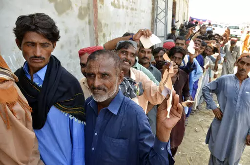 Displaced families, who fled their flood-hit homes, line up to get relief aid in Jaffarabad, a district of Baluchistan province, Pakistan, Wednesday, Sept. 21, 2022. Devastating floods in Pakistan's worst-hit province have killed 10 more people in the past day, including four children, officials said Wednesday as the U.N. children's agency renewed its appeal for $39 million to help the most vulnerable flood victims. (AP Photo/Zahid Hussain)