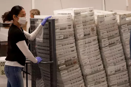 An election worker arrives with ballots to be tabulated inside the Maricopa County Recorders Office, Wednesday, Nov. 9, 2022, in Phoenix. (AP Photo/Matt York)