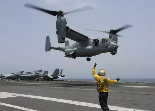 FILE -In this image provided by the U.S. Navy, Aviation Boatswain's Mate 2nd Class Nicholas Hawkins, signals an MV-22 Osprey to land on the flight deck of the USS Abraham Lincoln in the Arabian Sea on May 17, 2019. When the U.S. military took the extraordinary step of grounding its fleet of V-22 Ospreys this week, it wasn't reacting just to the recent deadly crash of the aircraft off the coast of Japan. The aircraft has had a long list of problems in its short history. (Mass Communication Specia