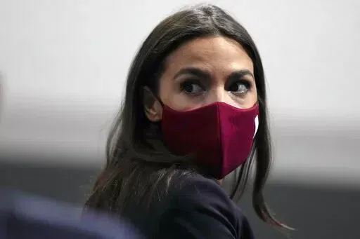 U.S. Rep. Alexandria Ocasio-Cortez looks round to listen to a question at the COP26 U.N. Climate Summit, in Glasgow, Scotland, Wednesday, Nov. 10, 2021. Ocasio-Cortez has tested positive for COVID-19 and “is experiencing symptoms and recovering at home,” her office said in a statement Sunday, Jan. 9, 2022. (AP Photo/Alastair Grant, File)