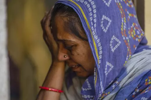 Naseema Ben Shamdar, 40, a survivor of a bridge collapse, weeps at her house in Morbi town of western state Gujarat, India, Tuesday, Nov. 1, 2022. Naseema and seven members of her family were walking on the congested suspension bridge when its cables gave away, sending them all plunging head-first into the wide Machchu river. She lost her daughter Muskan, 21, two nephews, two nieces and two sister-in-laws that night. (AP Photo/Rafiq Maqbool)