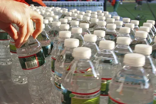 A runner grabs a bottle of water at the athlete's village prior to the start of the 116th running of the Boston Marathon, in Hopkinton, Mass., on April 16, 2012. (AP Photo/Stew Milne, File)