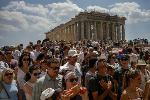 Atop the Acropolis ancient hill, tourists visit the Parthenon temple, background, in Athens, Greece, Tuesday, July 4, 2023. Crowds are packing the Colosseum, the Louvre, the Acropolis and other major attractions as tourism exceeds 2019 records in some of Europe’s most popular destinations. While European tourists helped the industry on the road to recovery last year, the upswing this summer is led largely by Americans, who are lifted by a strong dollar and in some cases pandemic savings. (AP P