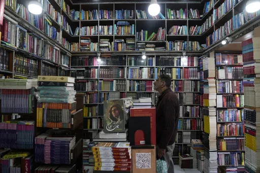 A Kashmiri man looks inside a book shop in Srinagar, Indian controlled Kashmir, Monday, Feb.17, 2025. (AP Photo/Mukhtar Khan)