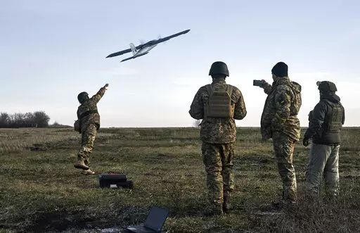 Ukrainian soldiers launch a drone at Russian positions near Bakhmut, Donetsk region, Ukraine, Thursday, Dec. 15, 2022. (AP Photo/LIBKOS)