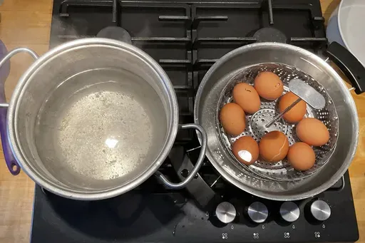 This photo provided by researchers in February 2025 shows two pots, one with boiling water, left, and the other with a basket of eggs in lukewarm water, in a new method of boiling eggs dubbed "periodic cooking." (Emilia Di Lorenzo, Ernesto Di Maio via AP)