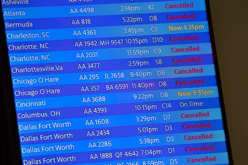 The arrivals board at the American Airlines terminal at LaGuardia Airport displays the flights that have been canceled or delayed and one that is on time, March 21, 2020, in New York. Flight delays and cancellations have bedeviled airline travel so far this year. The Transportation Department is launching a customer service dashboard to assist vacationers ahead of the travel-heavy Labor Day weekend. (AP Photo/Mary Altaffer, File)