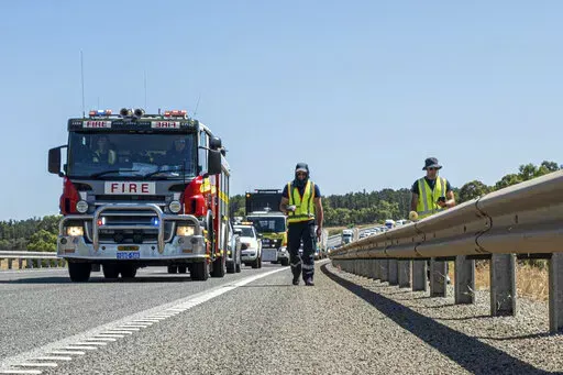 In this photo provided by the Department of Fire and Emergency Services, its members search for a radioactive capsule believed to have fallen off a truck being transported on a freight route on the outskirts of Perth, Australia, Saturday, Jan. 28, 2023. A mining corporation on Sunday apologized for losing the highly radioactive capsule over a 1,400-kilometer (870-mile) stretch of Western Australia, as authorities combed parts of the road looking for the tiny but dangerous substance. (Department 