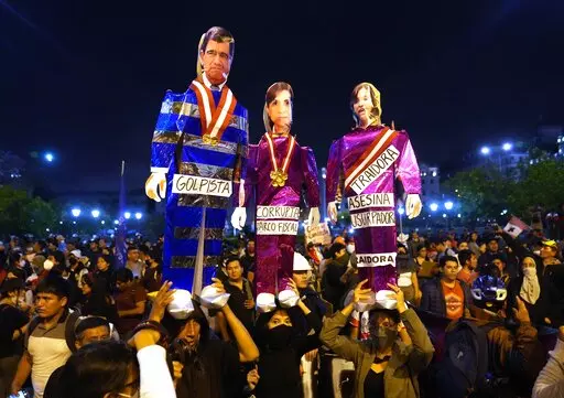 Supporters of ousted Peruvian President Pedro Castillo hold puppets depicting President of Congress Jose Williams, from left, Attorney General Patricia Benavides and Peru's new President Dina Boluarte, during a protest in Lima, Peru, Thursday, Dec. 15, 2022. A Peruvian judge on Thursday ordered Castillo to remain in custody for 18 months, approving a request from authorities for time to build their rebellion case against him. (AP Photo/Martin Mejia)