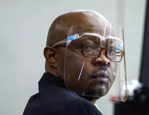 Accused serial killer Billy Chemirmir looks back ahead of his retrial on Monday, April 25, 2022, at Frank Crowley Courts Building in Dallas. The retrial of Chemirmir, charged with killing 18 older women in the Dallas area over a two-year span, began Monday, after the first jury to hear a case against him deadlocked last fall. (Shafkat Anowar/The Dallas Morning News via AP, Pool)