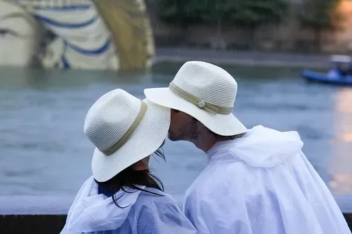 A couple kisses while on the Seine in Paris, France, during the opening ceremony of the 2024 Summer Olympics, Friday, July 26, 2024. Can kissing for six seconds a day lead to a more intimate relationship? That’s what couples therapists John and Julie Gottman say. They have taught thousands of couples therapists that an elongated kiss can help their clients. (AP Photo/Rebecca Blackwell, File)