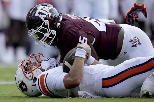 Texas A&M linebacker Edgerrin Cooper (45) gets in the face of Auburn quarterback Payton Thorne (1) after stopping him for a short gain on a run during the first quarter of an NCAA college football game Saturday, Sept. 23, 2023, in College Station, Texas. Cooper has been selected to The Associated Press midseason All-America team, Wednesday, Oct. 18, 2023.(AP Photo/Sam Craft, File)
