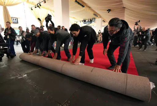 Crew members roll out the red carpet for Sunday's 96th Academy Awards at the Dolby Theatre, Wednesday, March 6, 2024, in Los Angeles. (AP Photo/Chris Pizzello)