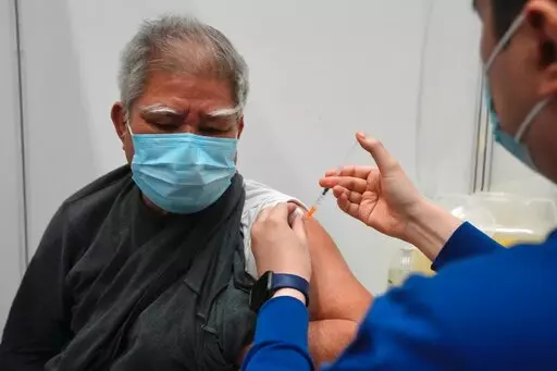 Hui Ngai-seng, 75, receives his first dose of China's Sinovac COVID-19 coronavirus vaccine at a community vaccination center in Hong Kong, Friday, Feb. 25, 2022. (AP Photo/Kin Cheung)