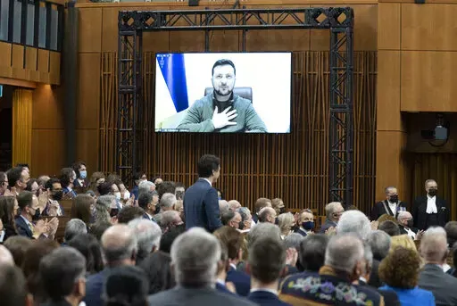 Ukrainian President Volodymyr Zelenskyy places his hand on his chest as he listens to Canadian Prime Minister Justin Trudeau deliver opening remarks before addressing the Canadian parliament, Tuesday, March 15, 2022 in Ottawa. (Adrian Wyld /The Canadian Press via AP)