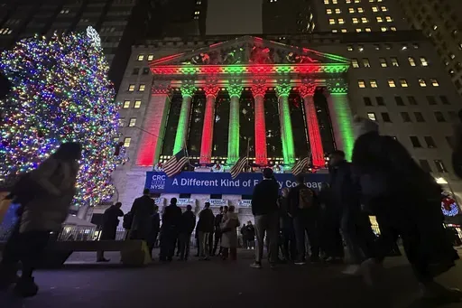 People gather in front of the New York Stock Exchange in New York's Financial District on Tuesday, Dec. 10, 2024. (AP Photo/Peter Morgan)