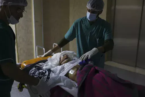 Doctors treat a child wounded in shelling at a hospital in the town of Idlib, Syria, Sunday, Nov. 6, 2022. Syrian government forces shelled tent settlements housing families displaced by the country's conflict in the rebel-held northwest early Sunday, killing at least six people and wounding dozens, opposition war monitors and first responders said. (AP Photo/Ghaith Alsayed)