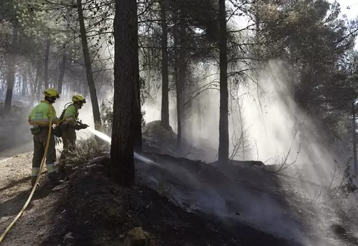 Firefighters try to extinguish a forest fire in Fuente la Reina, Castellon de la Plana, Spain, March 29, 2023. Spain suffered the biggest losses from wildfires of any European Union country last year amid a record-hot 2022, and there is worry that this year’s fire season could also be bad. (AP Photo/Alberto Saiz, File)