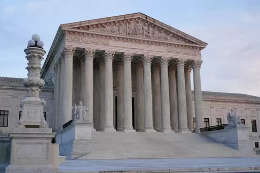 The setting sun illuminates the Supreme Court building on Capitol Hill in Washington, Tuesday, Jan. 10, 2023. The Supreme Court is allowing New York to continue to enforce a sweeping new gun law banning guns from “sensitive places” for now while a court challenge plays out. The justices on Jan. 11 turned away a plea by the law’s challengers. (AP Photo/Patrick Semansky)