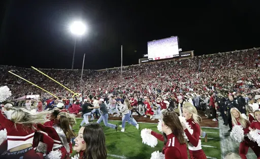 Oklahoma students and fans rush the field after Oklahoma defeated Alabama during a NCAA college football game Saturday, Nov. 23, 2024, in Norman, Okla. (AP Photo/Alonzo Adams)